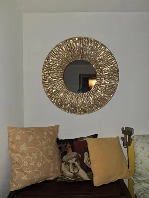 a mirror hanging on a wall above a couch at The Pilgrim's Court in Rome