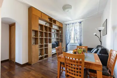 a dining room and living room with a table and chairs at Hostly-Roma Clelia Suite-Few Steps from S Giovanni in Rome