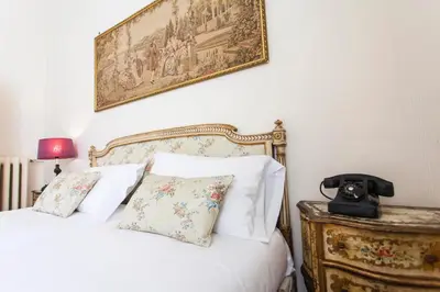 a bedroom with a white bed with a picture on the wall at Trastevere Decò Apartment in Rome