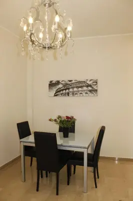 a dining room table with chairs and a chandelier at Casa Tony in Rome