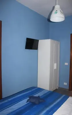 a blue room with a bed with a blue wall at B&B Isolatiberina in Rome