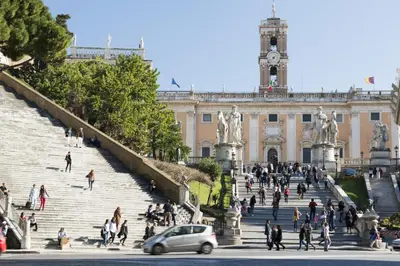 a group of people walking on stairs in front of a building at Rome Downtown Suite Bed and Breakfast Aracoeli in Rome