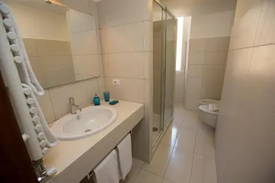 a white bathroom with a sink and a shower at AD2015 Guest House in Rome
