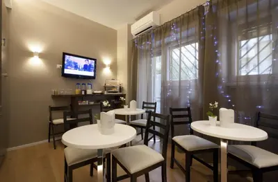 a restaurant with white tables and chairs and a tv at NG Guest House Roma San Pietro in Rome