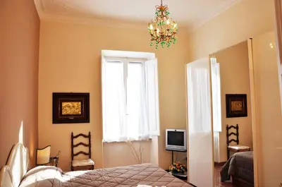 a bedroom with a bed and a window and a chandelier at Casa Visconti in Rome