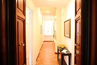 a hallway with a door and a table with flowers at Casa Visconti in Rome