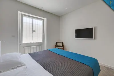 a bedroom with a bed and a tv on the wall at Piccolotel in Rome