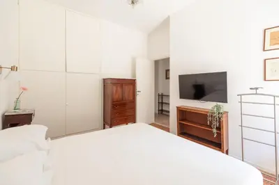 a bedroom with a white bed and a tv at Bright Family 5BR Apartment in Parioli in Rome