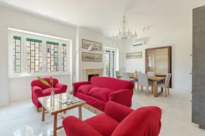 a living room with red chairs and a table at Bright Family 5BR Apartment in Parioli in Rome