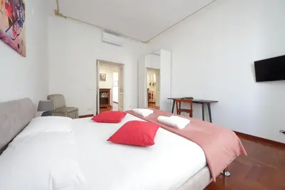 a bedroom with a large white bed with red pillows at 4BNB - St. Peters Dome Apartment in Rome