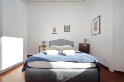 a bedroom with a bed with a blue blanket at 4BNB - St. Peters Dome Apartment in Rome