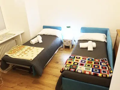 a room with two beds and a chair in it at CasaBlanca Apartment in Rome