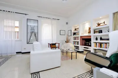 a living room with white furniture and bookshelves at Clementina in Rome