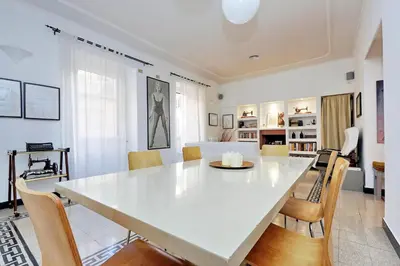 a dining room with a white table and chairs at Clementina in Rome