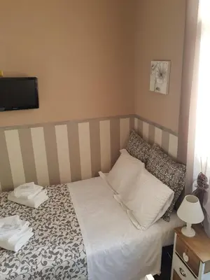 a bedroom with a bed and a tv on the wall at Morgagni House in Rome