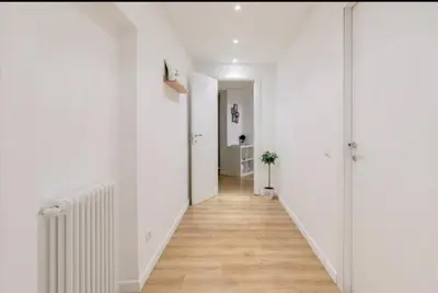 a hallway with white walls and a wooden floor at Charming 25 Apartment in Rome