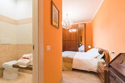 a bathroom with a bedroom with a bed and a toilet at A Roman Tale B&B in Rome