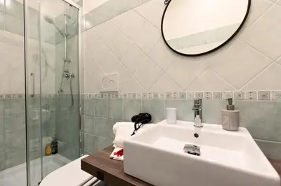 a bathroom with a sink and a shower and a mirror at A Roman Tale B&B in Rome