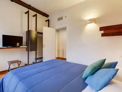 a bedroom with a large blue bed with blue pillows at Folia Domus in Rome