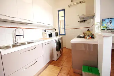 a white kitchen with a sink and a dishwasher at Walk to the Colosseum from your Family Apt in Rome