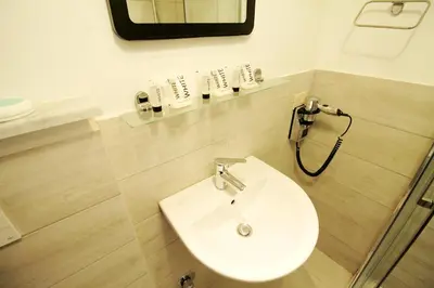 a bathroom with a white sink and a mirror at Walk to the Colosseum from your Family Apt in Rome