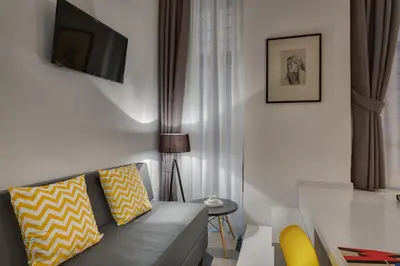 a living room with a couch and a tv at Navona Theatre Hotel in Rome