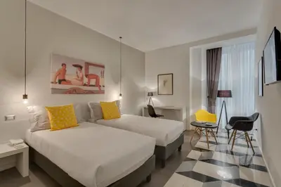 a hotel room with two beds and a table at Navona Theatre Hotel in Rome