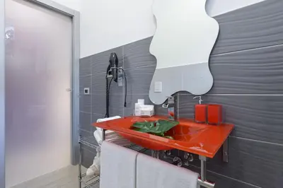 a bathroom with a red sink and a mirror at Tama Rooms in Rome
