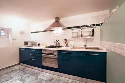 a kitchen with blue cabinets and a sink at TrastevereHome - Sales Rome in Rome