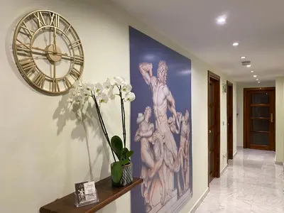 a large painting on the wall with a clock at Guest House Laocoonte in Rome