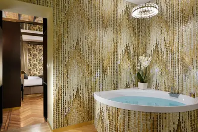 a bathroom with a tub with a patterned wall at Lifestyle Suites Rome in Rome