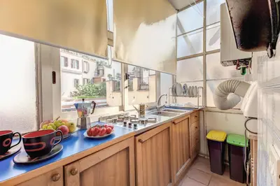 a kitchen with wooden cabinets and a sink and a window at Frangipane Apartment in Rome