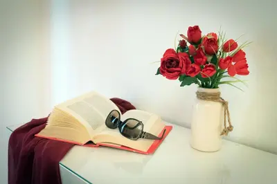 a vase with a book and a vase with roses at Vatican Art Place in Rome