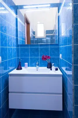 a blue tiled bathroom with a sink and a mirror at Vatican Art Place in Rome