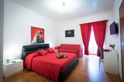 a bedroom with a red bed and a red couch at Vatican Art Place in Rome