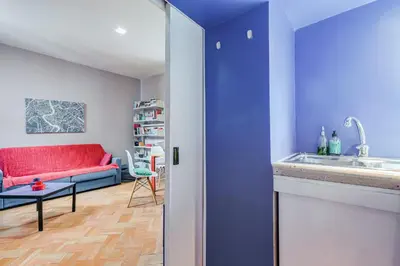 a kitchen and a living room with a red couch at Campo Marzio Boutique Apt 300 mt dal Pantheon in Rome