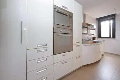 a kitchen with white cabinets and stainless steel appliances at Il Villino di Adelchi by DomusDimore in Rome
