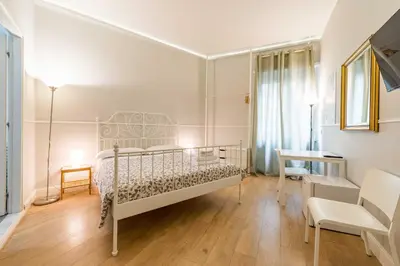a bedroom with a bed and a desk and a chair at Un Attimo A Roma B&B in Rome