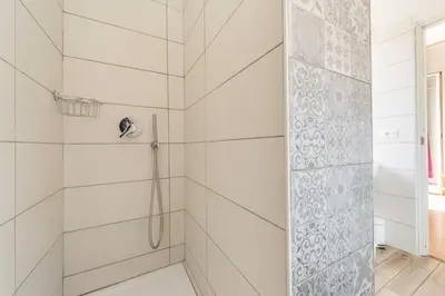 a bathroom with a shower with white tiles at Un Attimo A Roma B&B in Rome