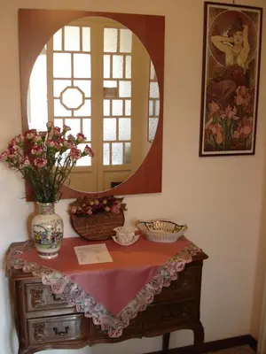 a dressing table with a mirror and a vase with flowers on it at B&B La Bella Giuliana in Rome