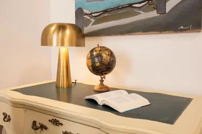 a table with a lamp a book and a globe at Avila Palace Piazza Navona in Rome