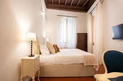 a white bedroom with a bed and a window at Avila Palace Piazza Navona in Rome