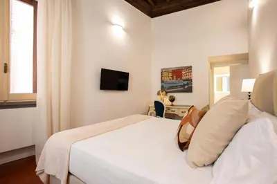 a bedroom with a white bed and a television at Avila Palace Piazza Navona in Rome