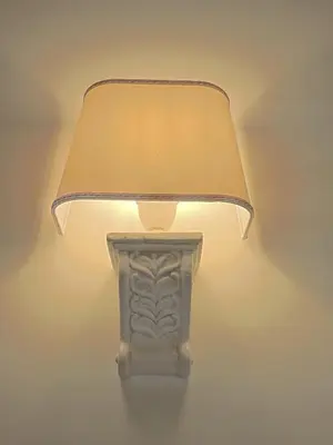 a lamp with a lamp shade on a wall at Anfiteatro Suite in Rome