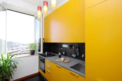 a yellow kitchen with yellow cabinets and a window at La Dolce Vista Trastevere in Rome