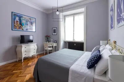 a bedroom with a bed and a desk and a television at Athena Guest House in Rome
