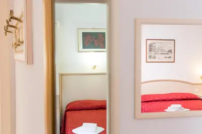 a mirror in a room with a red bed at Best Suites Pantheon in Rome
