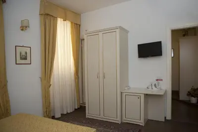 a bedroom with a white cabinet and a television at Best Suites Pantheon in Rome