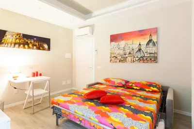 a bedroom with a bed with red pillows and a table at Un Passino da San Pietro Casa in Rome