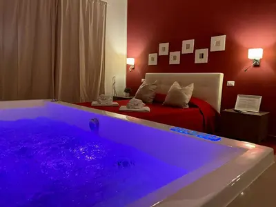 a bedroom with a large tub with a bed at Le Coq Suites in Rome
